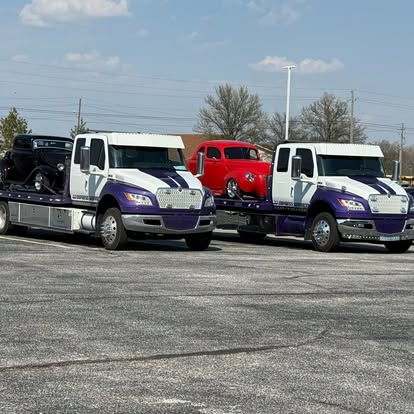 Two J&J Express Services rollback trucks carrying classic vehicles