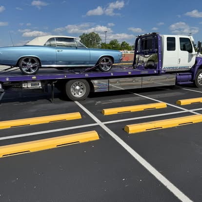 Classic car secured on a purple and white J&J Express Services rollback
